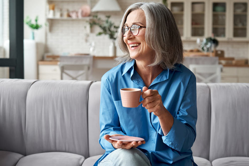 Happy mature woman drinking coffee